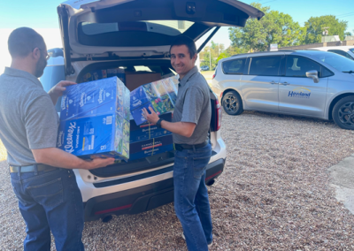 Aaron and employee loading up car to deliver School Supplies to Argonia